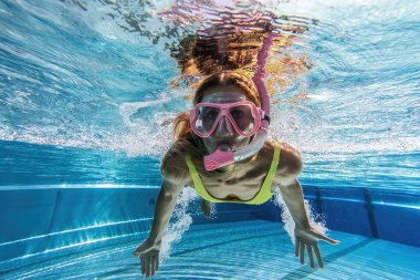 Yüzme havuzunda kaplıca merkezinde maske takan bir kadın suya daldı. Seyahat yaşam tarzı, su sporu macerası, yaz tatillerinde yüzme dersleri..