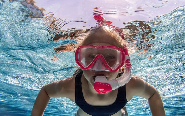 stock image child with snorkeling mask diving in underwater in swimming pool. water sport outdoor adventure, swimming lessons on summer holidays.