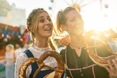 İki kız arkadaş Bavyera panayırında ya da oktoberfest 'te ya da milli kostüm içinde aldatılmış ya da krakerli ya da brezenli Dirndl' de