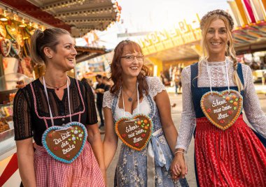 Kız arkadaşlar Dirndl 'deki Bavyera panayırında ya da oktoberfest' te Schenk mir dein Herz, Du bist die beste (Almanca: Bana kalbini ver, sen en iyisisin) zencefilli çörekler üzerine yazılmış