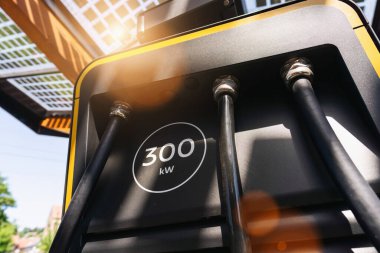 EV şarj istasyonunda DC CCS tip 2 EV konnektörlü modern hızlı 300KW hiperşarj cihazı veya hibrit PHEV otomobiller için Supercharger. Fiş ve Şarj konsepti resmi.
