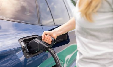 Kadın, şarj istasyonu, hiperşarj cihazı veya süperşarj cihazında DC CCS2 EV bağlantısını elektrik prizine yerleştiriyor. Elektrohareketlilik konseptini yükle.