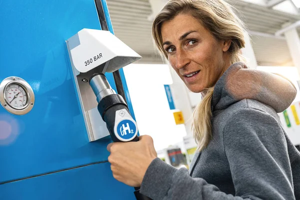 Frau Hält Zapfsäule Mit Wasserstoff Logo Tankstelle Ihr Auto Betanken — Stockfoto