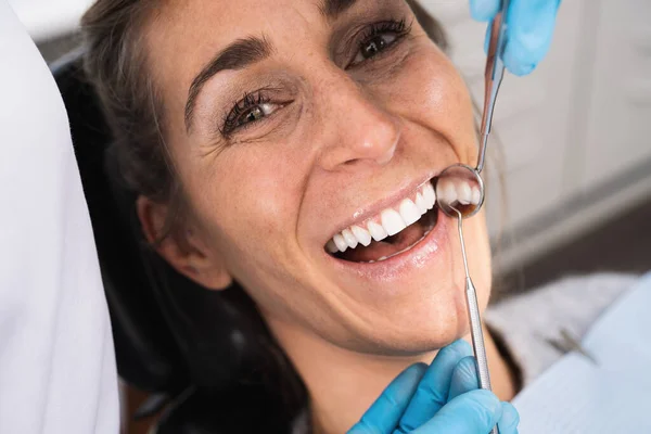 在牙医中检查女病人牙齿的牙医 — 图库照片