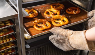 Fırıncı fırından taze Bavyera krakerleri alıyor.