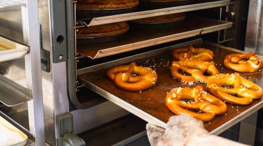 Baker fırından fırından taze Bavyera krakerleri alıyor.