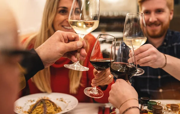 friends having fun drinking and toasting red wine at italian restaurant - Young people eating italian food at restaurant winery together, Dining lifestyle concept image