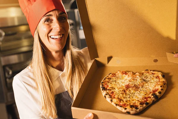 Šťastná Žena Pizza Pekař Drží Čerstvý Sýr Pizza Tvaru Srdce — Stock fotografie