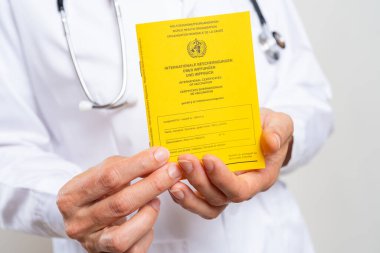 Tıbbi doktor koronavirüs aşısı, covid-19 ya da grip aşısı için uluslararası sertifika gösteriyor.