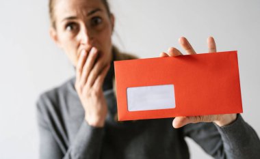 Şok olmuş bir kadın, elinde kırmızı zarf tutarak avukat ya da işveren kavramı iamını hatırlatacak bir mektup tutarak, kişisel metniniz için metin alanı oluşturur..