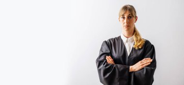 Beyaz bir duvardaki mahkeme salonunda kollarını kavuşturmuş kameraya bakan avukat kadın. Hukuk ve adalet kavramı, afiş boyutu, bireysel metinleriniz için telif alanı.