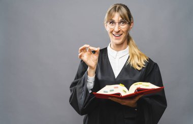 Medeni hukuk kitabına sahip kadın bir avukat mahkeme salonunda doğru bir şekilde imza attığını gösteriyor. Hukuk ve adalet kavramı imajı