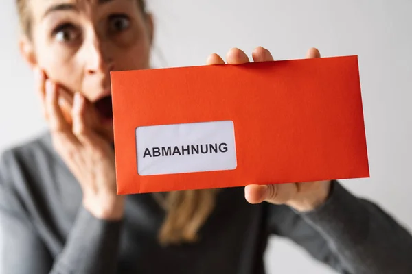 Abmahnung (German for: final notice) Hand Holding and showing a Receiving a Final Notice Envelope concept of lawyer or business