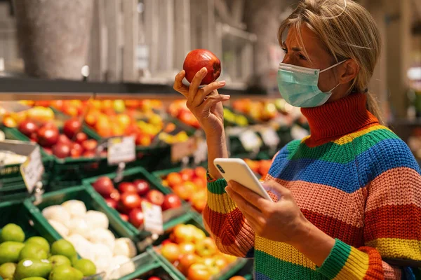 Mujer Supermercado Sección Frutas Eligiendo Fruta Con Teléfono Inteligente Usando — Foto de Stock