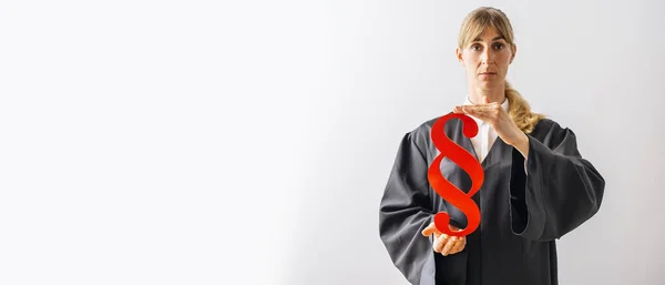 stock image Lawyer with red paragraph sign in a court room on a white wall. Law and justice concept, banner size, with copyspace for your individual text.