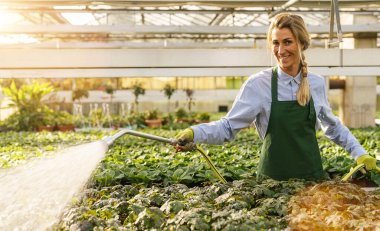 Bahçıvan çiçekleri çocuk odasında ya da bahçe merkezinde suyla suluyor.