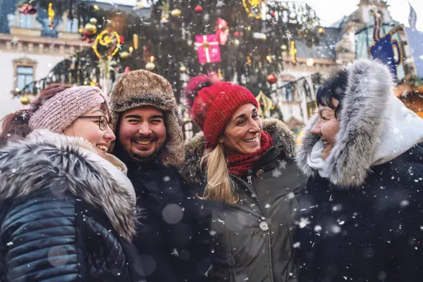 Joyful group of friends meeting and sharing a laugh at a Christmas market