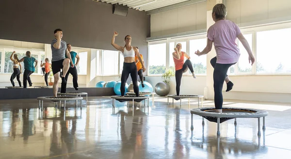 Group of people exercising on mini trampolines in a bright fitness studio