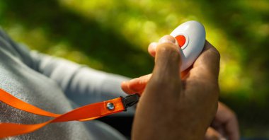 Kıdemli adam parkın dışındaki acil durum çağrısı için alarm düğmesine basıyor..