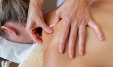 Müşterinin sırtına baskı uygulayan bir masaj terapistinin yakın çekimi.