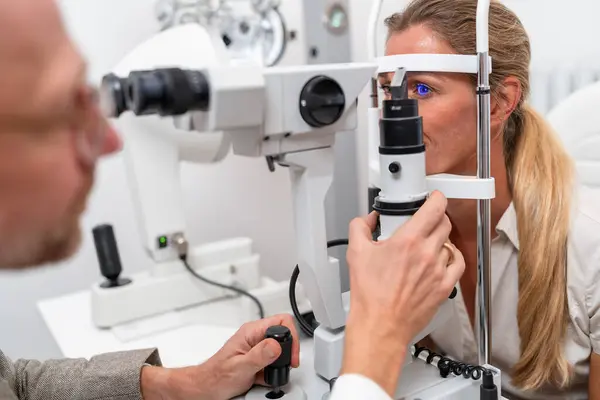 眼科クリニックでスリットランプを調整する眼科医との眼科検査のクローズアップ クローズアップ写真 医療と医療のコンセプト ロイヤリティフリーのストック写真