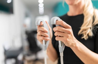 Bir kadının ellerinin, vücut kompostomlarının saplarını tutarken yakın plan fotoğrafı.