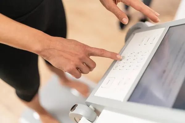 在健身室进行体格测试时 人的手在体格构成尺度的触摸屏界面上输入数据 免版税图库图片
