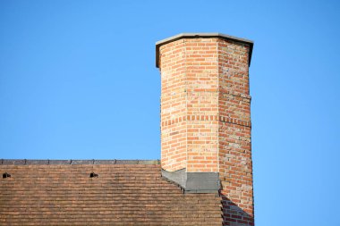 Mavi gökyüzünde izole edilmiş büyük bir evin bacası.