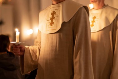 Ellerinde mum tutan insanların resmi. Noel ve Lucia tatilleri