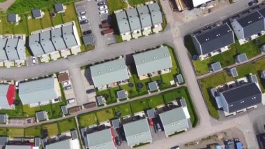 Otoparkları ve bahçeleri olan modern İskandinav tarzı evlerin üst düzey insansız hava aracı manzarası. Yüksek kalite 4k görüntü