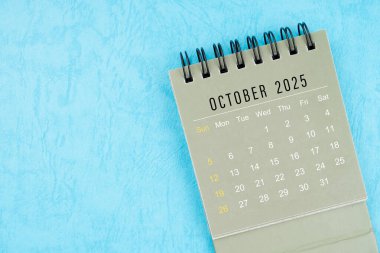 Ekim 2025 Masa Takvimi mavi arkaplanda kopya alanı ile.