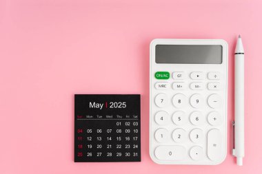 Mayıs 2025 takviminin üst görünümü ve pembe arkaplanlı beyaz hesap makinesi, kopyalama alanı olan konum.