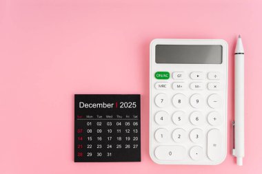 Aralık 2025 takviminin üst görünümü ve pembe arkaplanlı beyaz hesap makinesi, kopyalama alanı olan konum.