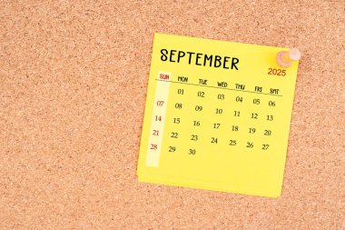 Tahta raptiyeli Eylül 2025 için sarı takvim kağıdı.
