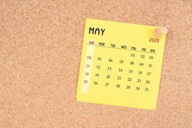 Tahta raptiyeli Mayıs 2025 için sarı takvim kağıdı.