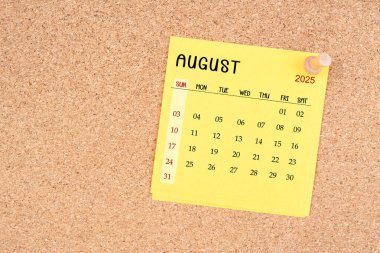 Tahta raptiyeli Ağustos 2025 için sarı takvim kağıdı.