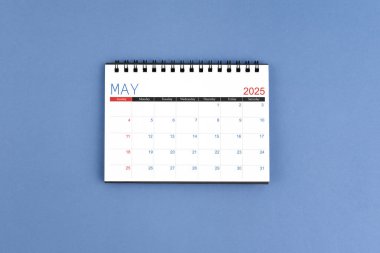 Mayıs 2025 'te mavi arkaplanlı 2025 yıllık masa takvimi. Düz yatıyordu.