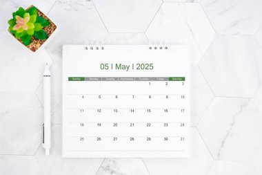 Desk calendar on month of May 2025 with pen on white marble color background. clipart