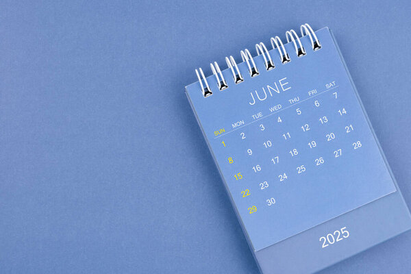 June 2025 calendar on blue color background. Desk calendar for planning and organizing.