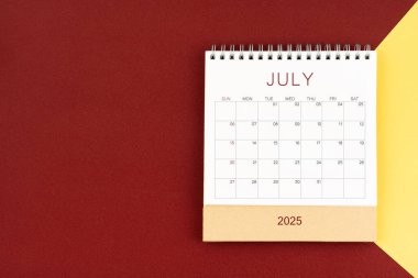 Kırmızı ve sarı arkaplan üzerine Temmuz 2025 boş masa takvimi, düz yatıyordu.