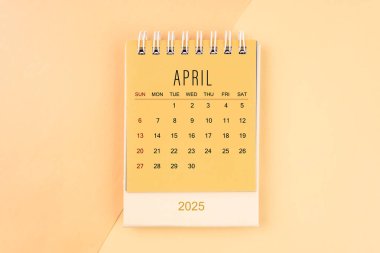 Nisan 2025 sarı takvime küçük masa takvimi, iş toplantısı konsepti için planlama.