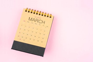 Pembe arka planda, Mart 2025 için kahverengi takvim. Planlama kavramı.