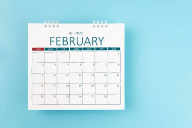 2025 Şubat ayının masa takvimi mavi arka planda 2025 yıl için. Düz yatıyordu.