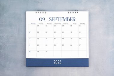 Eylül 2025, gri çimento duvar arka planında masa takvimi. Planınız için yıllık takvim sayfası.