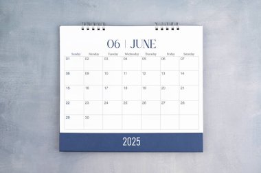 Haziran 2025, gri çimento duvar arka planında masa takvimi. Planınız için yıllık takvim sayfası.