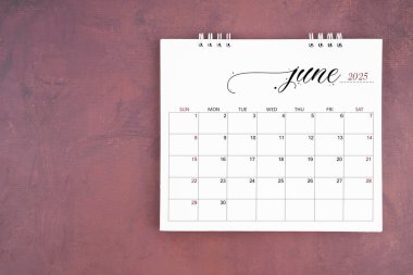 June 2025 desk calendar on red cement wall background. Page of annual monthly calendar for plan.	