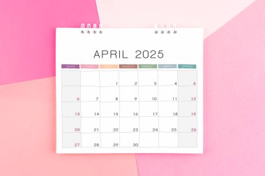 Kağıt renkli arkaplanda 2025 yıllık Nisan ayı masa takvimi.