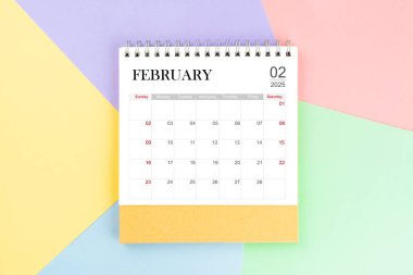 Renkli arkaplanda 2025 yıllık Şubat ayı masa takvimi.
