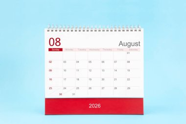 2026 Ağustos ayının masa takvimi mavi arkaplan üzerine.
