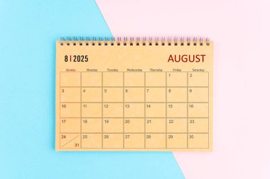 Ağustos 2025 Pembe ve mavi arkaplan üzerine kahverengi kağıt takvim.